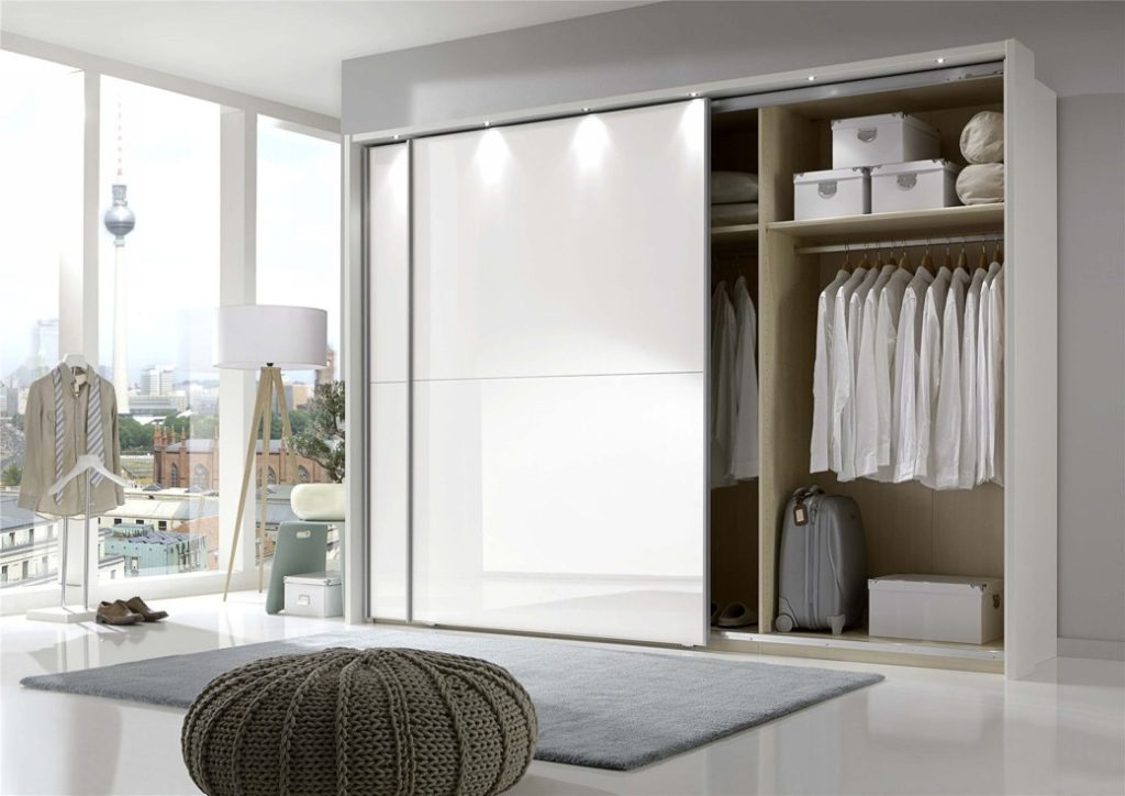 White sliding door wardrobe with hanging shirts and storage boxes inside