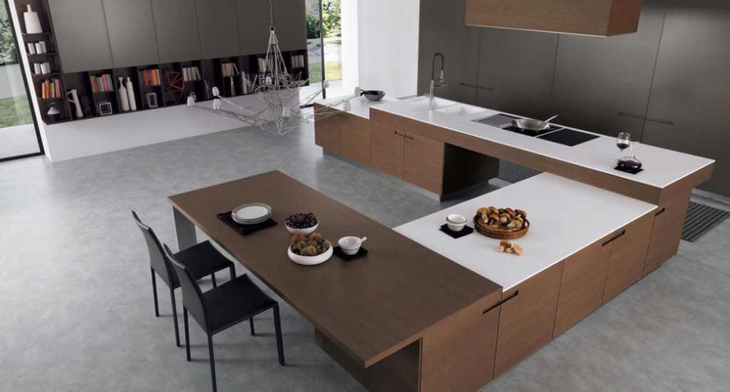 U-shaped kitchen with wood and white surfaces, integrated sink, cooktop, and dining area with two chairs