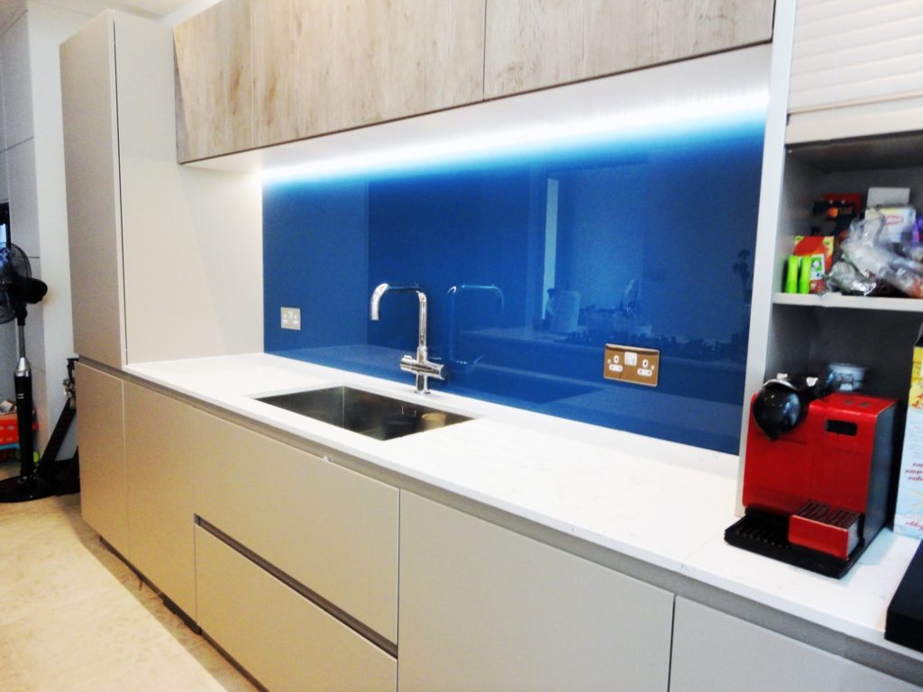 Kitchen countertop with stainless steel sink and blue glass splashback