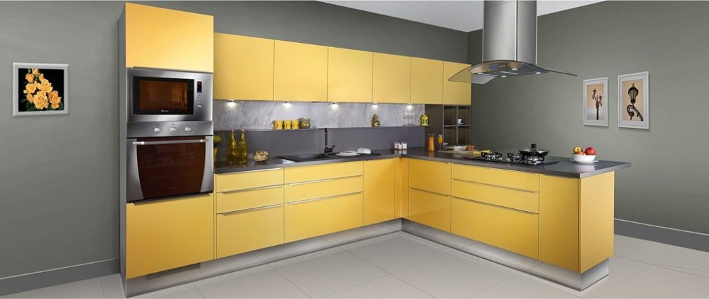 Yellow L-shaped kitchen cabinetry with built-in oven and microwave under stainless steel extractor