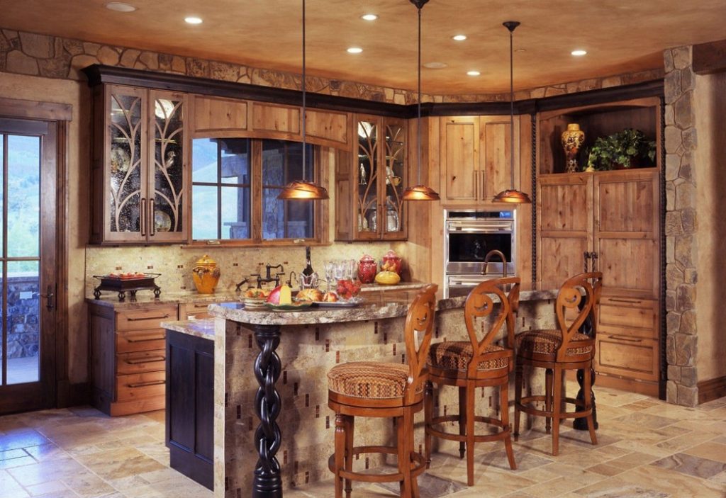 Kitchen with wooden cabinetry, stone walls, granite countertops and three wooden bar stools
