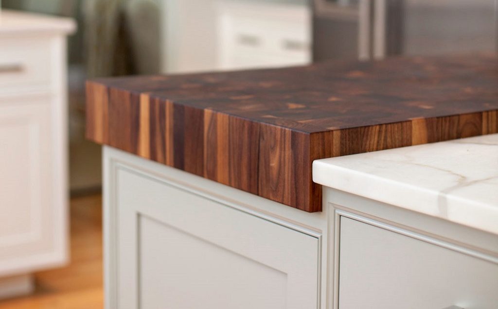Close-up of a thick wooden butcher block countertop on a kitchen island