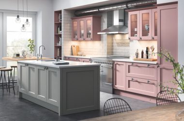 Luxury hand-painted farmstyle kitchen by Weizter Kitchens featuring blush pink shaker cupboards, a grey central island, stainless steel range cooker and classic country-style finishes.