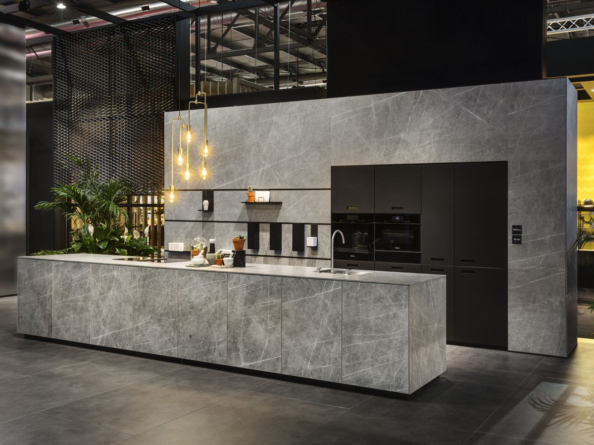 Modern industrial-style kitchen with dark charcoal cupboards, a natural wood island, black countertops and copper pendant lights.