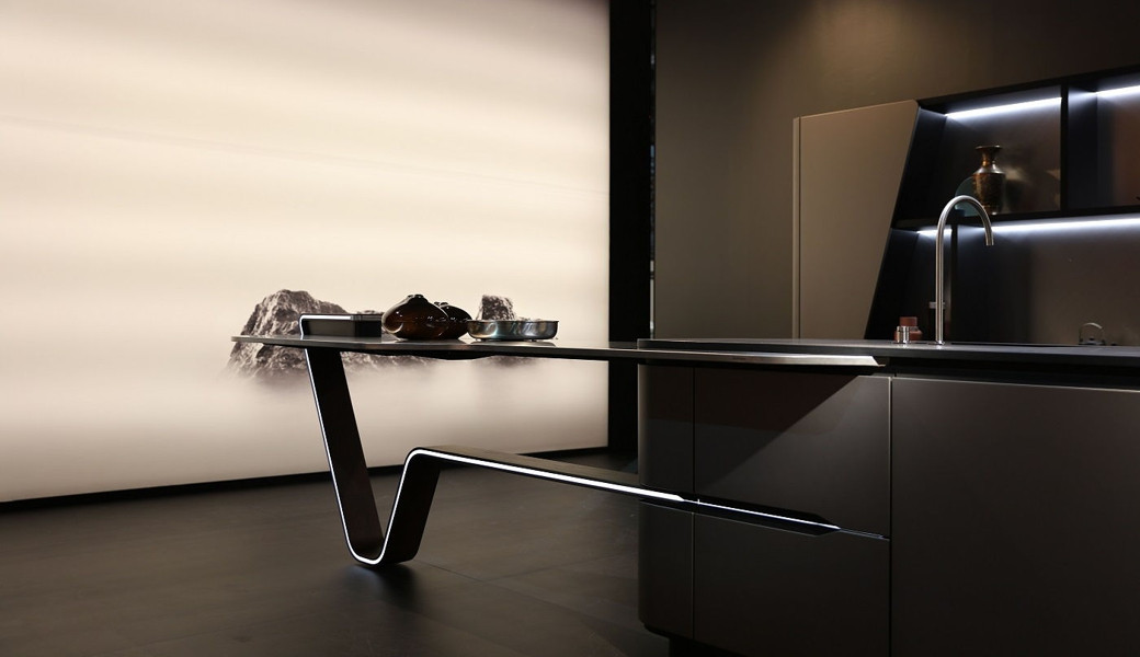 Minimalist ultra modern kitchen with dark cabinetry, sleek cantilevered island, and soft ambient lighting.