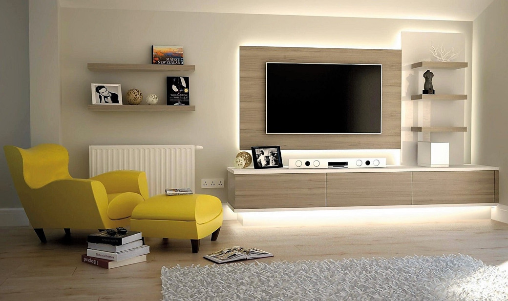 Living room with a modern wooden TV cabinet, mounted flat-screen TV, yellow armchair with matching ottoman, books, and decora