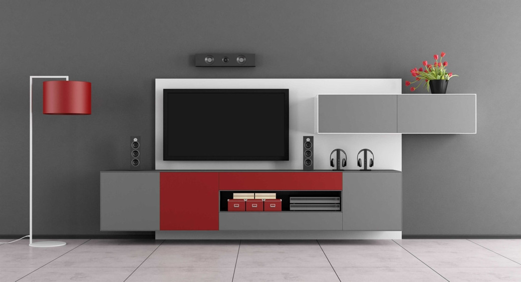 Modern grey and red custom TV unit with wall-mounted TV, speakers, headphones, and a red floor lamp on tiled floor.