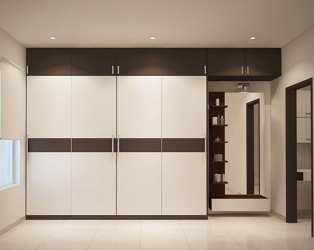 Bedroom wardrobe with white and dark brown doors, overhead cupboards, built-in mirror, and open shelves on cream tiled floor.