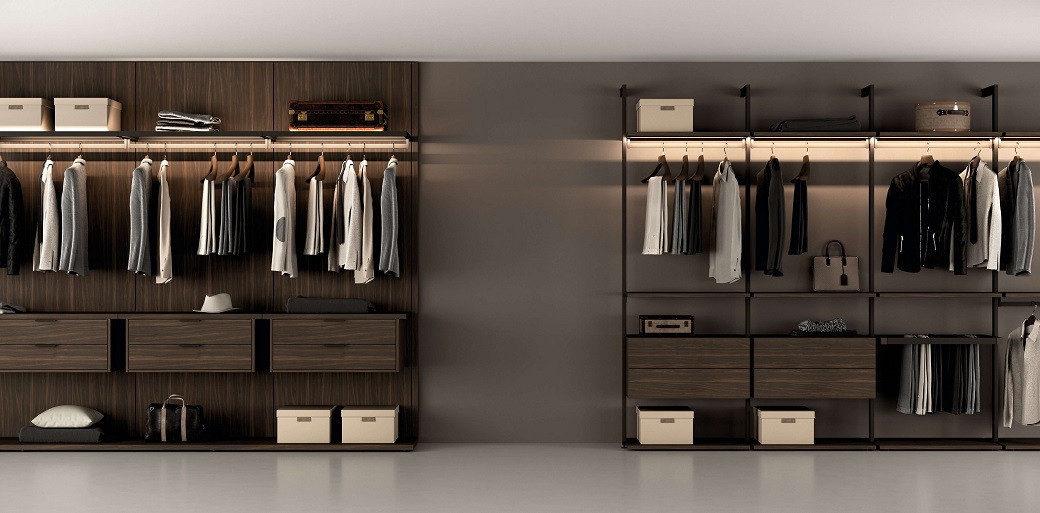 Modern walk-in closet with wooden shelves, hanging jackets and shirts, storage boxes, bags, and soft lighting.
